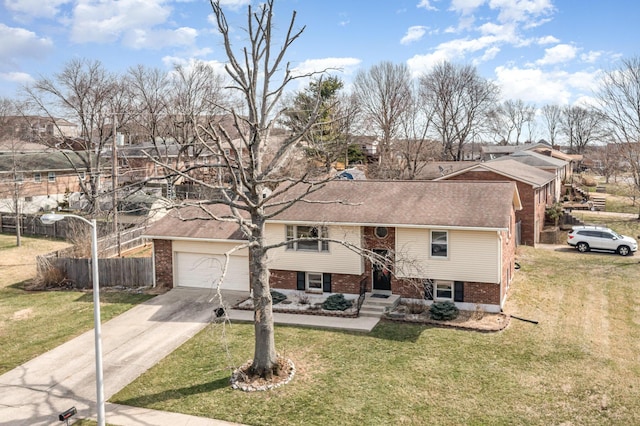 split foyer home featuring brick siding, a garage, driveway, and a front lawn