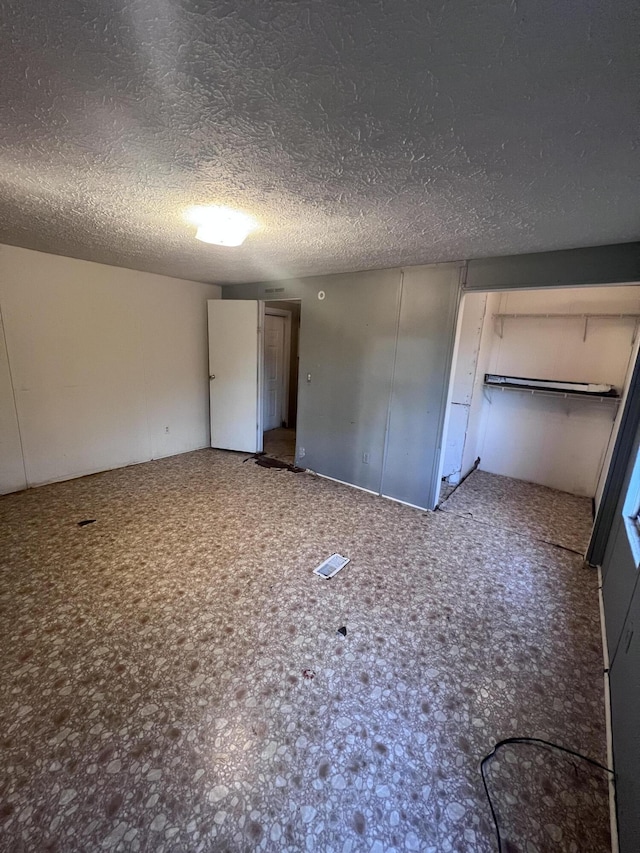 unfurnished bedroom with a textured ceiling and visible vents