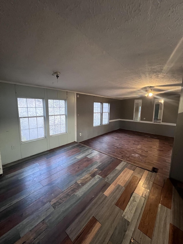 unfurnished living room featuring ceiling fan, a textured ceiling, and hardwood / wood-style floors