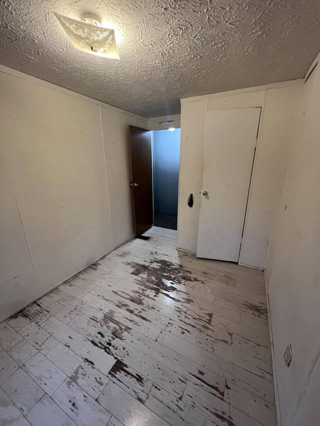 empty room featuring light wood-style flooring and a textured ceiling