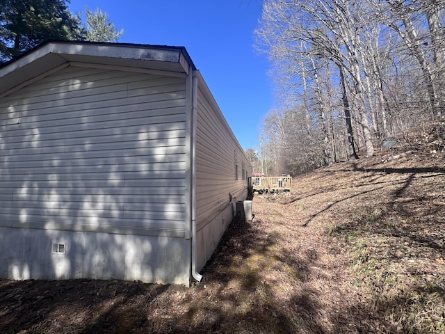 view of side of home with crawl space and central air condition unit