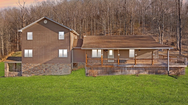 view of front of house featuring a lawn and roof with shingles