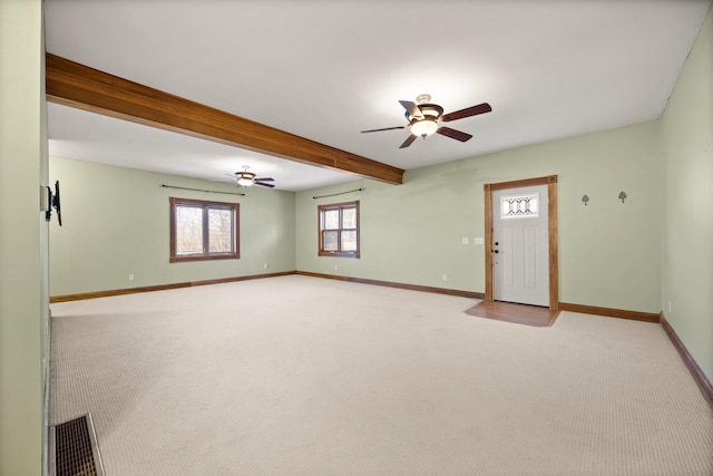 interior space featuring beamed ceiling, a ceiling fan, visible vents, and baseboards