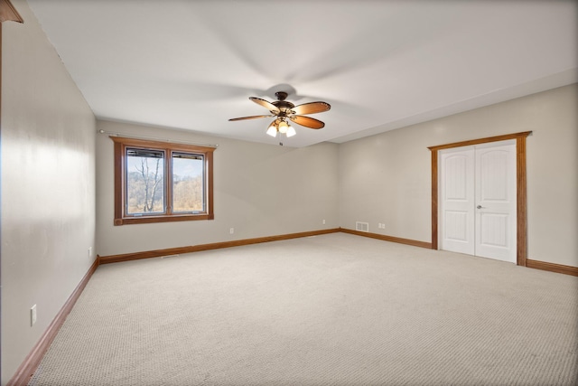 empty room with visible vents, light colored carpet, baseboards, and ceiling fan