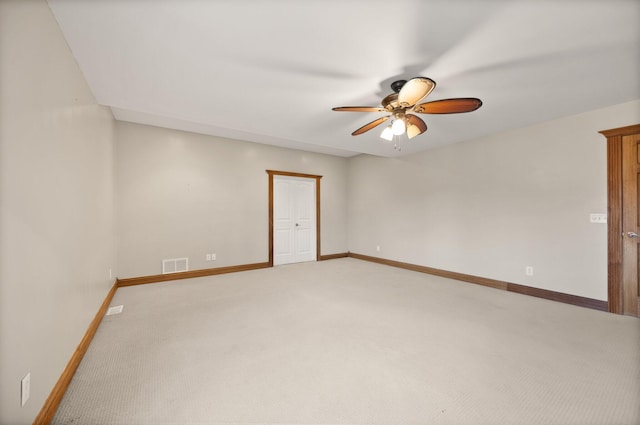 unfurnished room with light carpet, visible vents, baseboards, and a ceiling fan