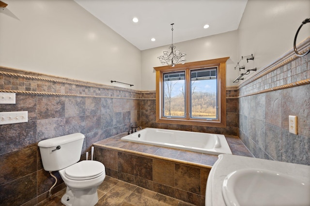 bathroom featuring a wainscoted wall, toilet, a garden tub, recessed lighting, and tile walls