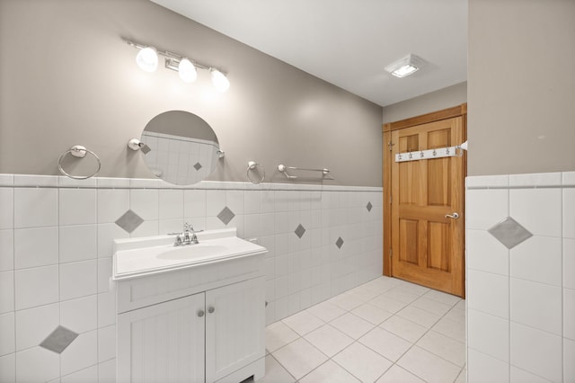 full bathroom featuring tile patterned floors, a wainscoted wall, tile walls, and vanity