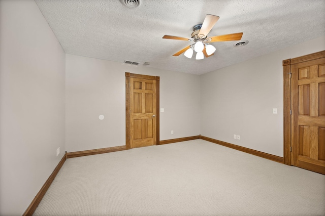 empty room featuring visible vents, baseboards, light colored carpet, and a ceiling fan