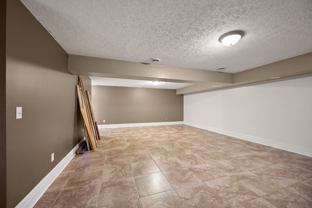 finished below grade area with a textured ceiling and baseboards