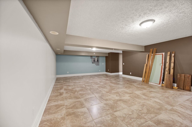 spare room featuring baseboards and a textured ceiling