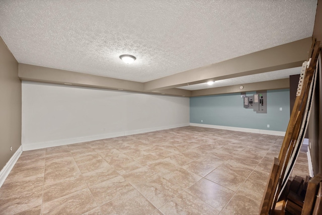 finished below grade area featuring a textured ceiling and baseboards