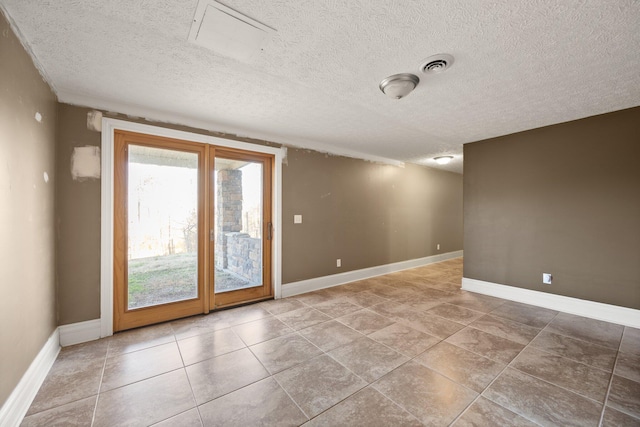 unfurnished room with visible vents, baseboards, and a textured ceiling