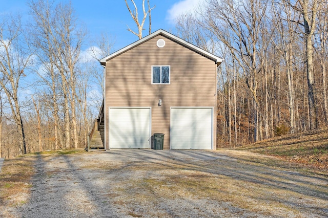 view of side of home featuring stairway and driveway