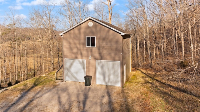 view of outdoor structure featuring driveway and a garage