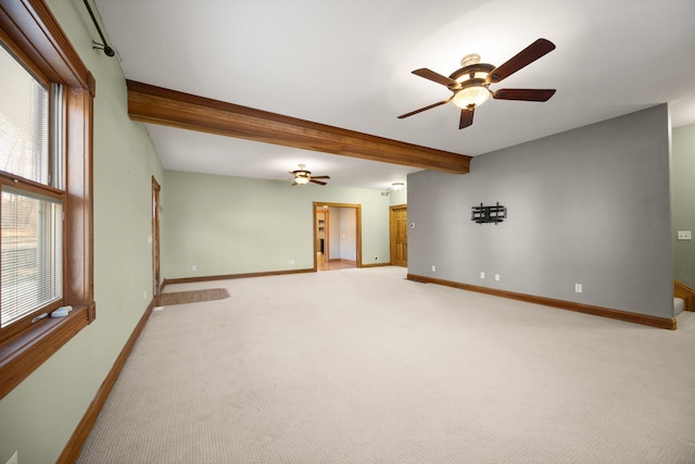 unfurnished room featuring beamed ceiling, light carpet, baseboards, and ceiling fan