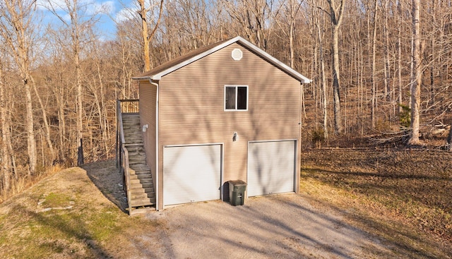 view of outbuilding featuring stairway and driveway