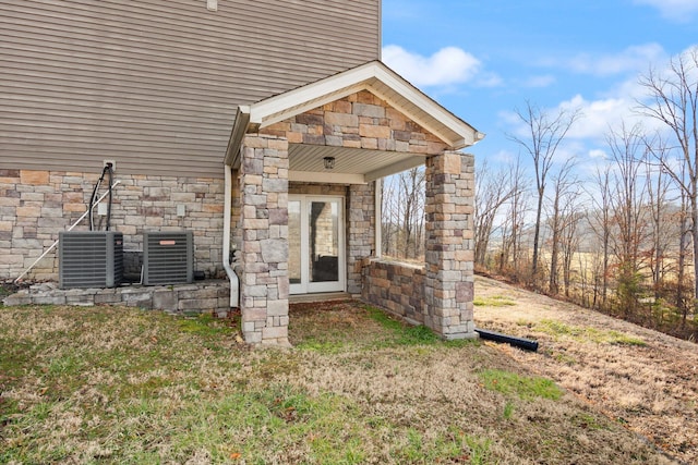 property entrance featuring central AC unit and stone siding