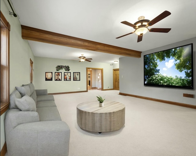 living area with baseboards, beam ceiling, light carpet, and a ceiling fan