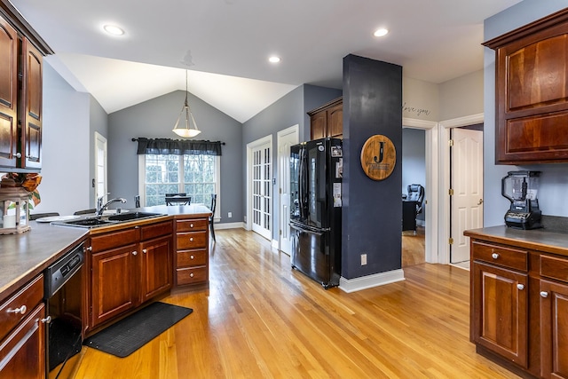 kitchen with light wood-style floors, lofted ceiling, a sink, and black appliances