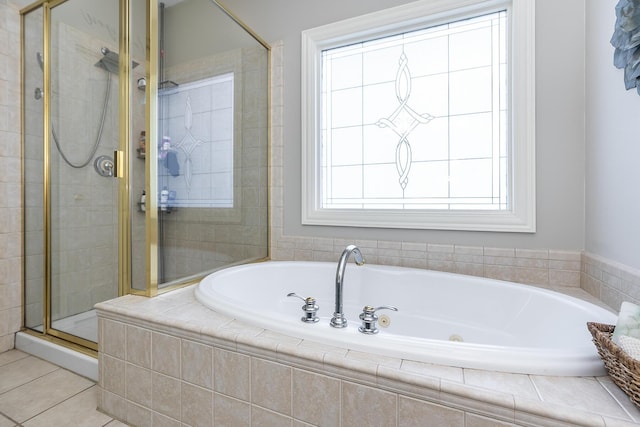 bathroom featuring a stall shower, a jetted tub, and tile patterned floors