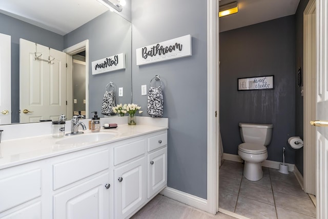 bathroom featuring toilet, vanity, baseboards, and tile patterned floors