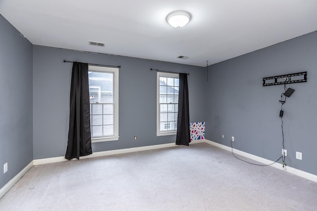 unfurnished room with light carpet, baseboards, and visible vents