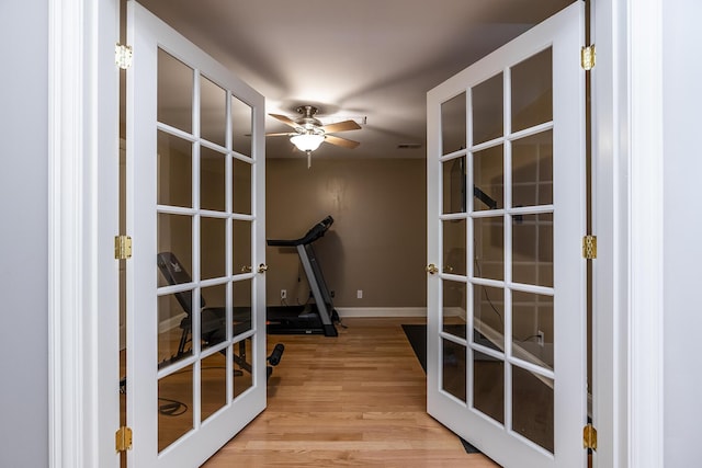 workout room with french doors, wood finished floors, a ceiling fan, and baseboards