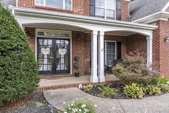 entrance to property featuring a porch and brick siding