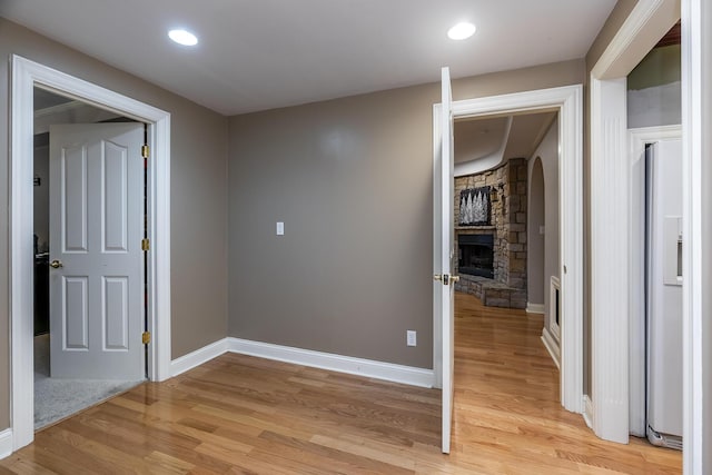 hall featuring light wood finished floors, baseboards, and recessed lighting