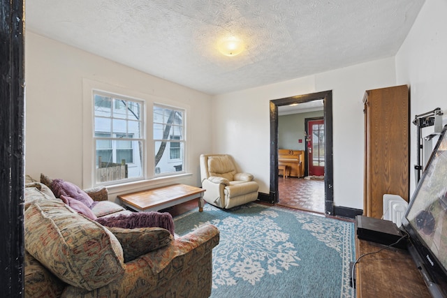 living area with a textured ceiling and baseboards