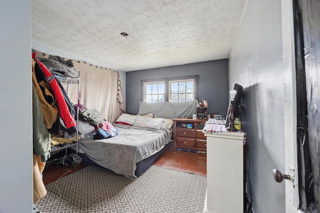 bedroom with a textured ceiling and wood finished floors
