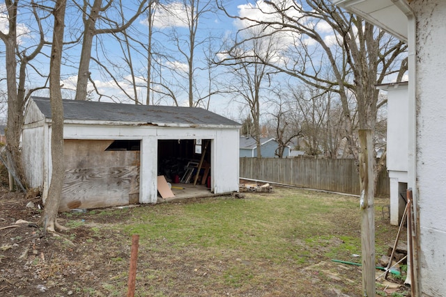 view of yard with fence, an outdoor structure, and a storage unit