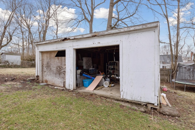view of shed featuring a trampoline and fence