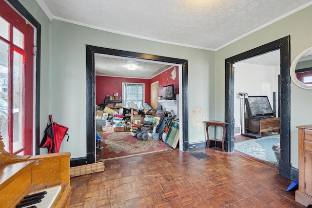 foyer featuring a textured ceiling, baseboards, and crown molding