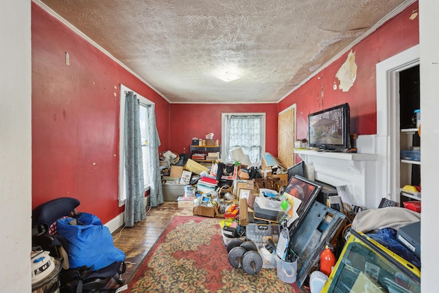interior space featuring a textured ceiling, wood finished floors, and crown molding