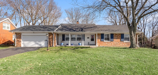 ranch-style home featuring driveway, brick siding, a front lawn, and an attached garage