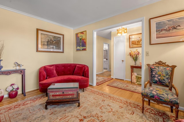 living area featuring crown molding, baseboards, and wood finished floors