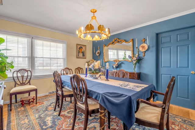 dining room featuring a notable chandelier, baseboards, crown molding, and wood finished floors