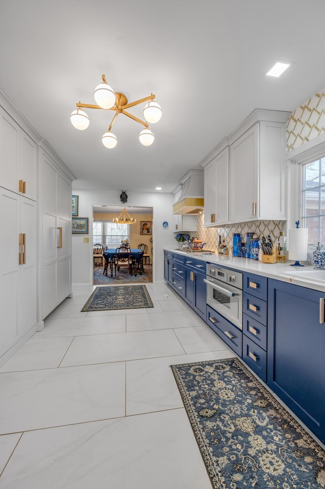 kitchen featuring blue cabinetry, tasteful backsplash, a wealth of natural light, and oven