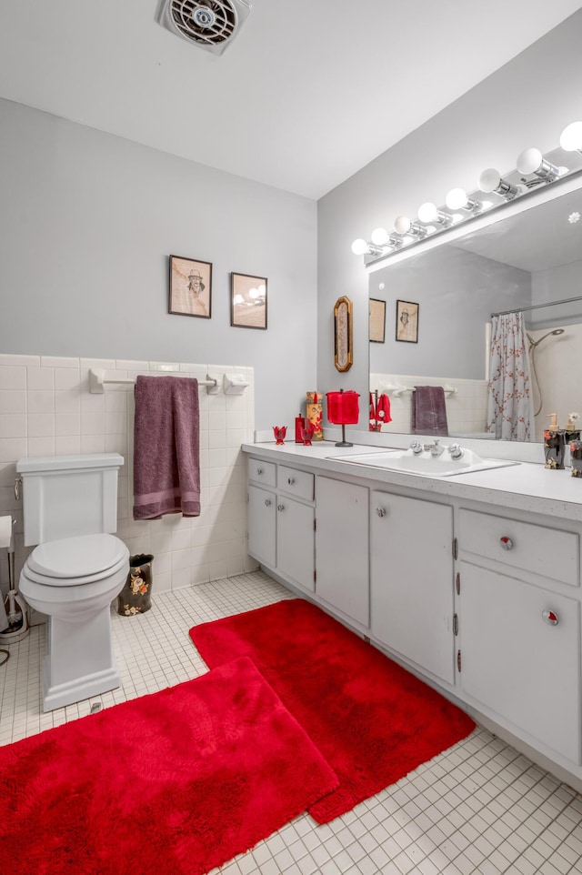 bathroom with wainscoting, visible vents, toilet, and tile patterned floors