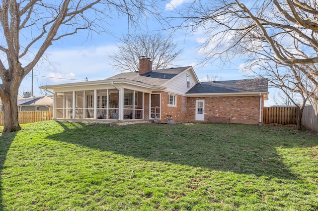 back of property featuring a fenced backyard, a yard, and brick siding