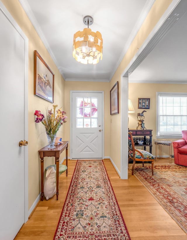 doorway to outside featuring an inviting chandelier, light wood-style flooring, and crown molding