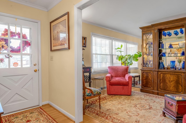 doorway with ornamental molding, baseboards, and wood finished floors