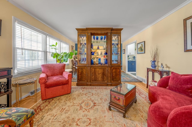 living room featuring baseboards, ornamental molding, and wood finished floors