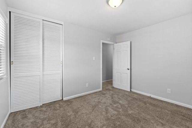 unfurnished bedroom with carpet, baseboards, and a closet