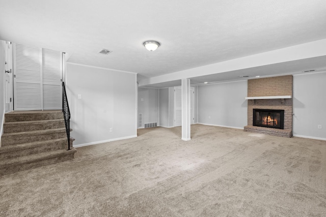 unfurnished living room with visible vents, baseboards, stairway, carpet, and a brick fireplace