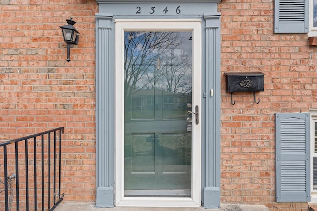 entrance to property featuring brick siding