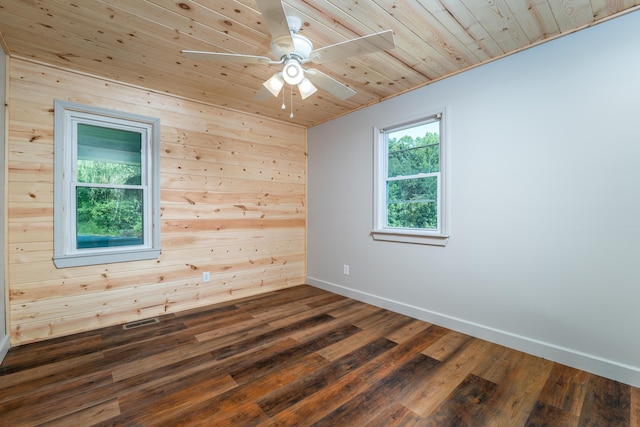 spare room with wooden ceiling, dark wood-style flooring, a ceiling fan, visible vents, and baseboards