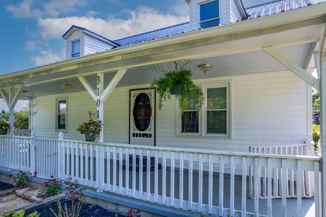 doorway to property with a porch and metal roof