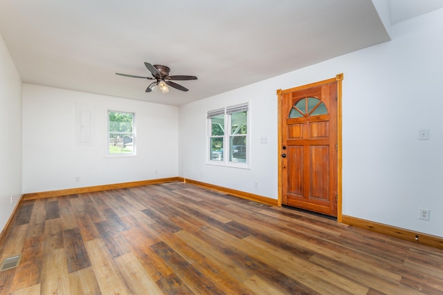 unfurnished room featuring a ceiling fan, visible vents, baseboards, and wood finished floors